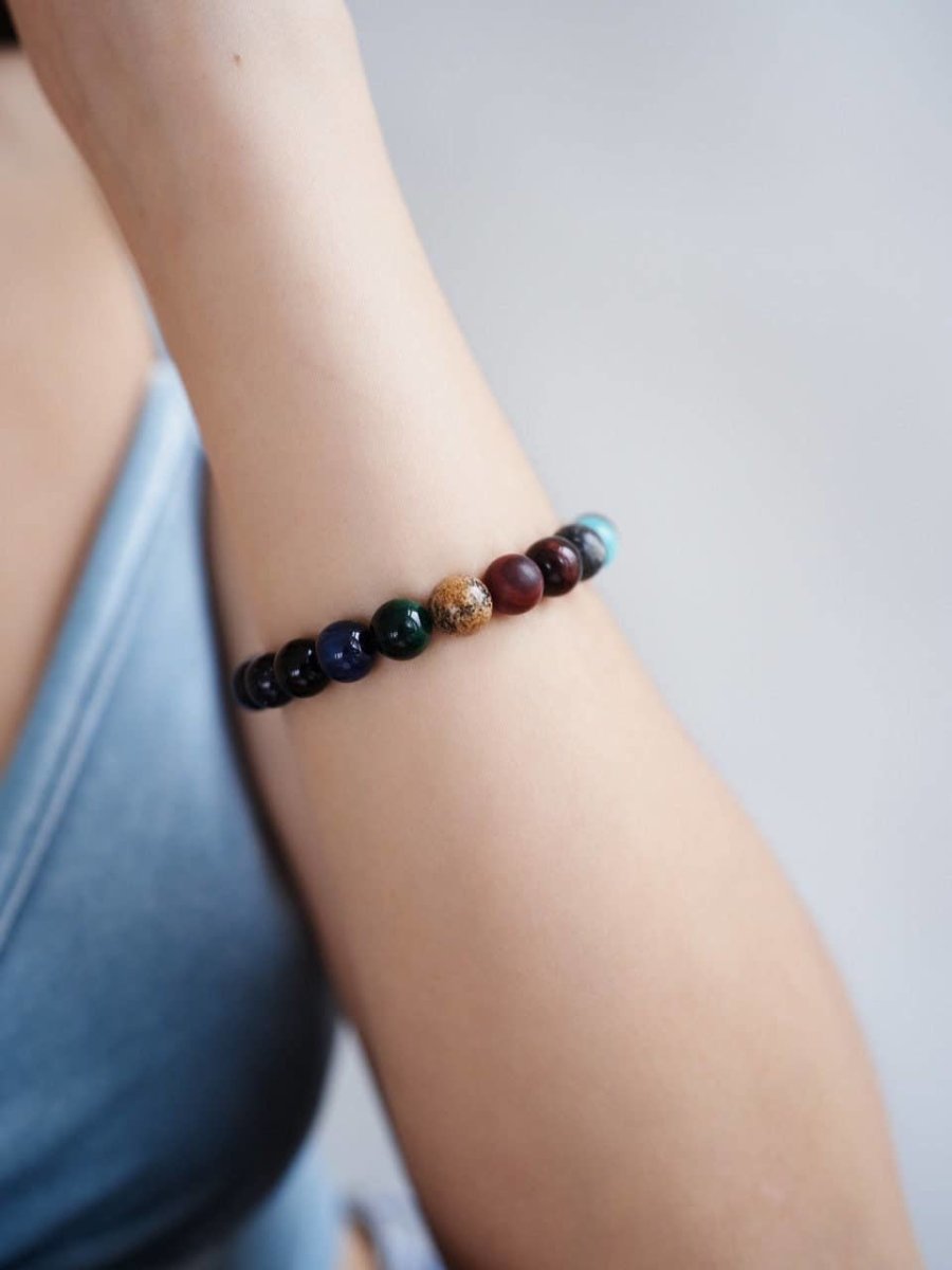 CosmoLuxe Solar System armband met kleurrijke kralen die de planeten voorstellen, gedragen om de pols voor een mystieke en inspirerende uitstraling.