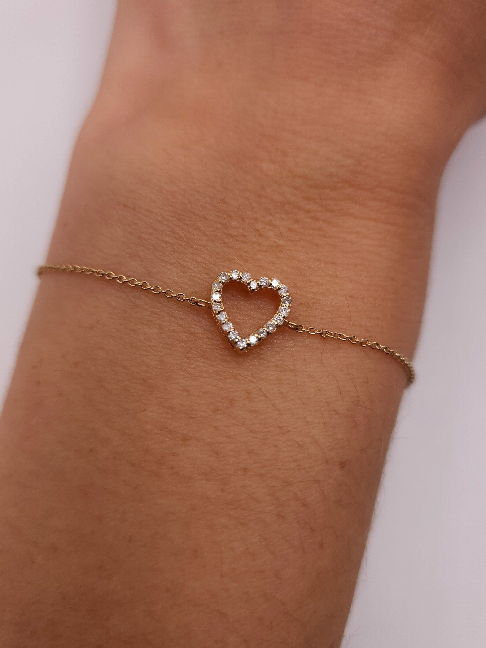 Afbeelding van de GlansLuxe armband met een hartvormige charm, bezet met fonkelende steentjes. Het elegante ontwerp maakt het een stijlvol en veelzijdig accessoire voor elke gelegenheid.