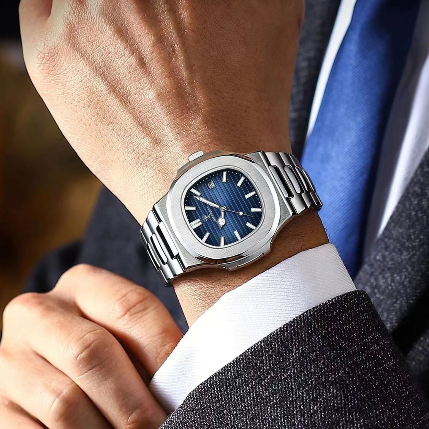 Een stijlvolle man draagt het Herenstijl Elegance horloge met een diepblauwe wijzerplaat en een roestvrijstalen band. Dit tijdloze en elegante accessoire benadrukt de verfijnde uitstraling en is perfect geschikt voor zowel formele als dagelijkse gelegenheden.