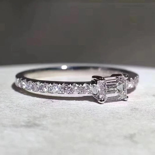 Kardé ring met een elegante, rechthoekige edelsteen en een verfijnde band bezet met fonkelende kleine steentjes. Perfect voor een tijdloze en luxe uitstraling.