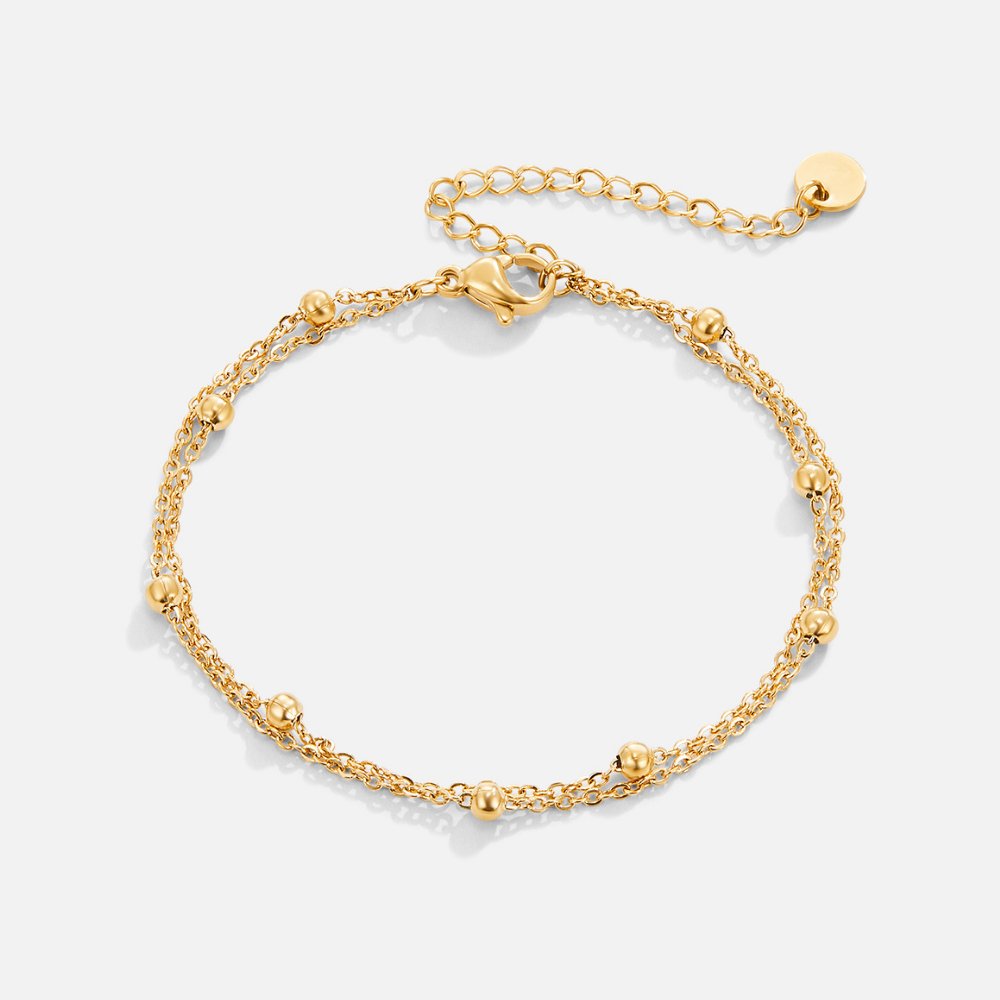 Close-up van een verfijnde gouden armband van Lichtgloed Luxe. Elegant ontwerp met subtiele kralen en een verstelbare sluiting, ideaal voor een stijlvolle en charmante look.