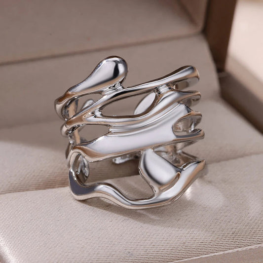 Zilverkleurige Liora ring met een uniek organisch ontwerp. De vloeiende, golvende vormen geven de ring een elegante en moderne uitstraling. Perfect voor een verfijnde look bij elke gelegenheid.