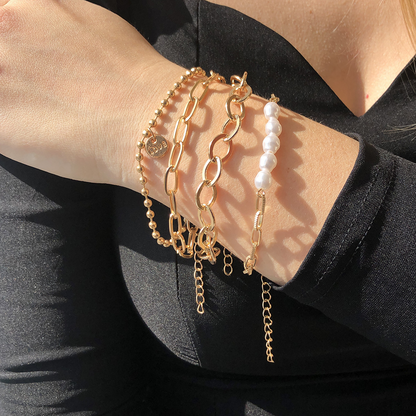 Een elegante close-up van de Lumineux Flair armband met gouden kralen, parels en stijlvolle schakels, perfect om een verfijnde luxe look te creëren.