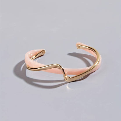 Lumineux Grace armband in roze en goud, met een elegant en modern ontwerp. Het tijdloze sieraad biedt een luxueuze uitstraling en is veelzijdig te combineren voor elke gelegenheid.