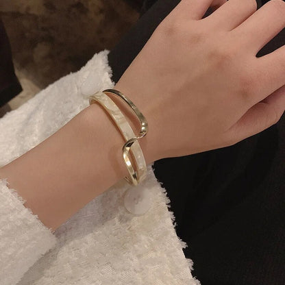 Lumineux Grace armband, een luxe accessoire met een tijdloos en veelzijdig ontwerp. De combinatie van goud en marmer creëert een verfijnde uitstraling die elke look verrijkt, perfect voor iedere gelegenheid.