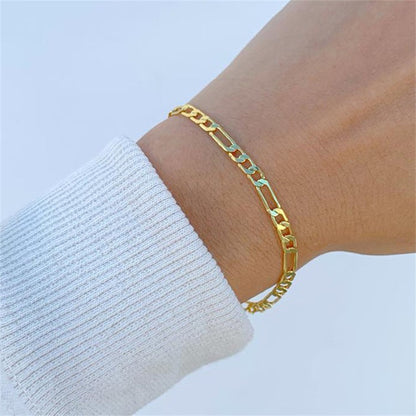 Gouden Lusso Vero armband met een slank en elegant ontwerp, gedragen om de pols van een persoon in een witte trui. Een verfijnd accessoire dat tijdloze stijl en klasse uitstraalt.