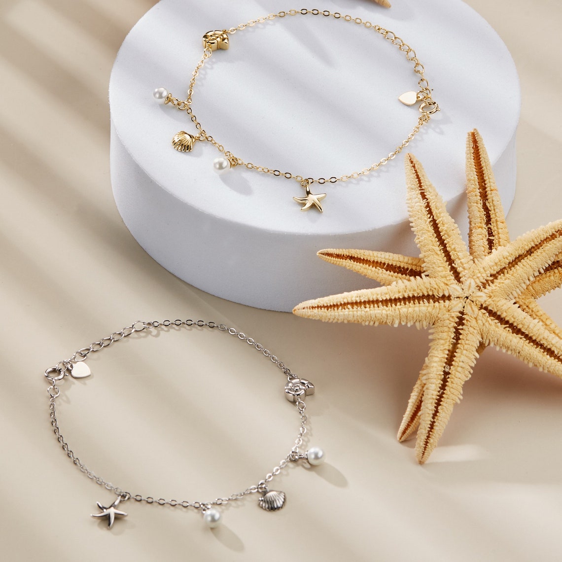 De Lustrous Joy armband is een charmant en verfijnd sieraad, met een gouden ketting versierd met delicate parels, een stervormige zeester en een schelp. Dit stijlvolle accessoire brengt de schoonheid van de oceaan naar jouw pols, met een elegante en speelse uitstraling die elke outfit aanvult. Perfect voor een verfijnde, maritieme charme.