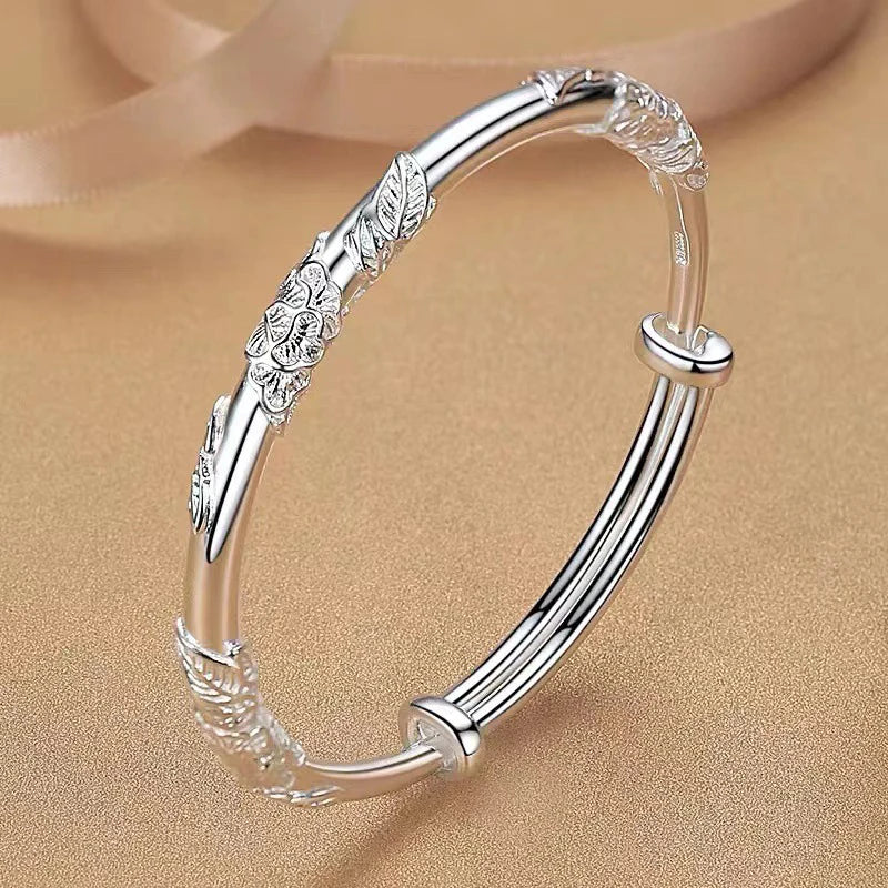 MiraLux armband met verfijnd bloem- en bladdetail op een gouden achtergrond. Deze elegante en veelzijdige armband straalt luxe uit en is perfect voor elke gelegenheid.