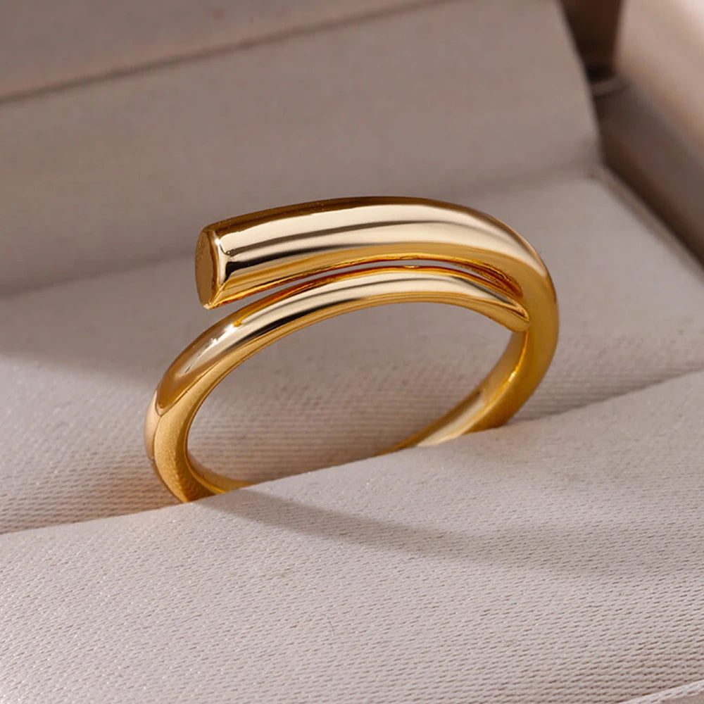 Goudkleurige ring met een modern, minimalistisch design. De ring heeft een unieke open vorm en straalt eenvoudige elegantie uit. Perfect voor een subtiele maar verfijnde toevoeging aan elke outfit.