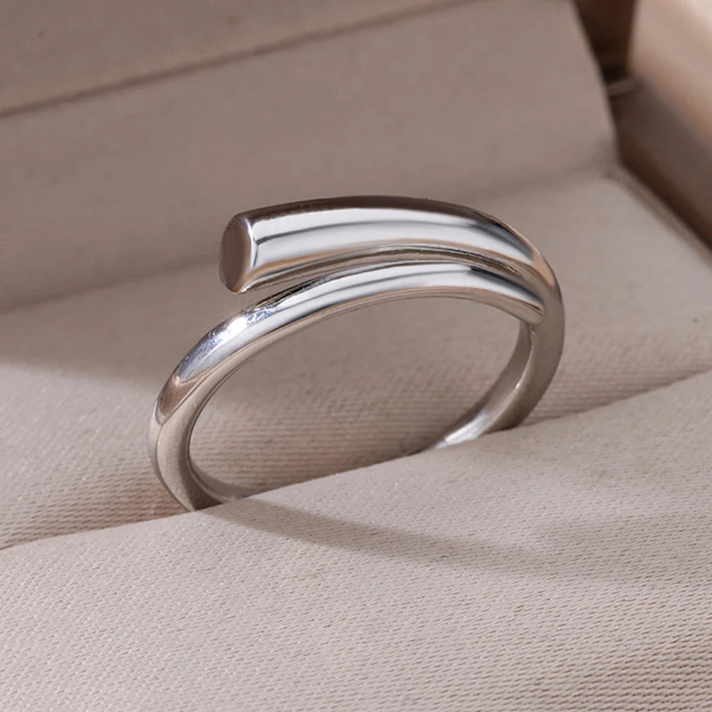 Zilverkleurige ring met een minimalistisch en modern design. De ring heeft een open, strakke vorm en straalt tijdloze elegantie uit. Perfect voor een subtiele, verfijnde uitstraling bij elke gelegenheid.