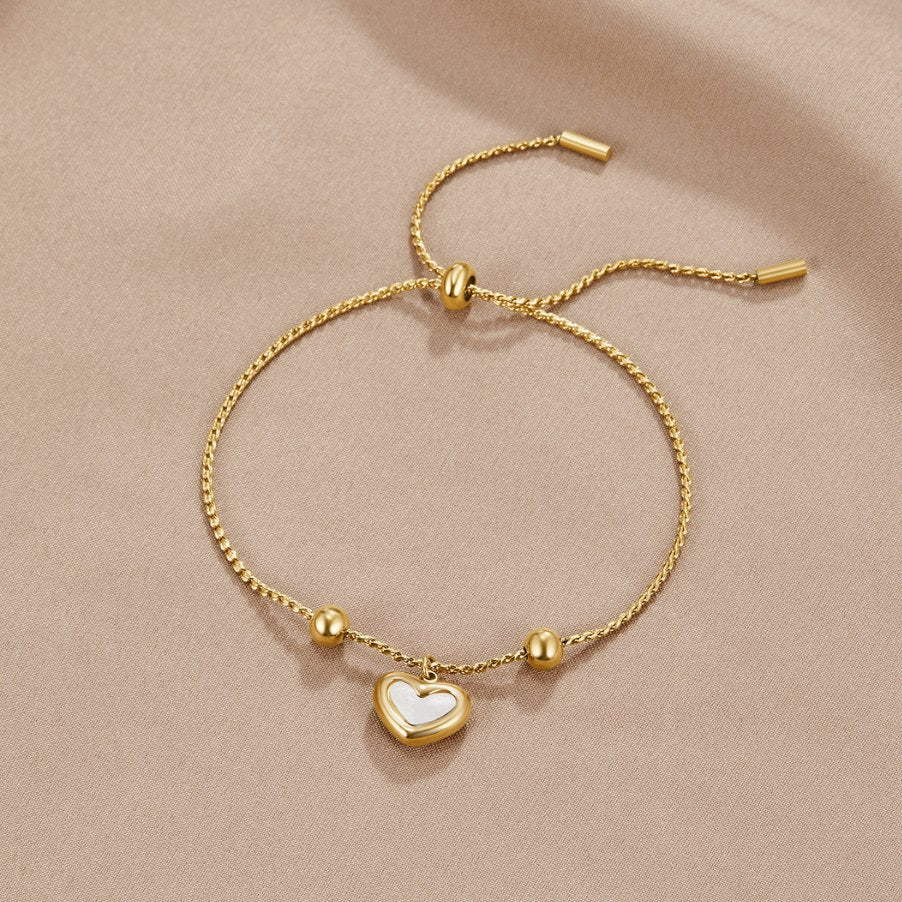 De SoulEmbrace armband met een liefdevol ontwerp, voorzien van een verfijnde gouden ketting en een charmant hartvormig hanger, straalt elegantie uit. Het verstelbare ontwerp biedt optimaal comfort en maakt het geschikt voor iedere polsmaat. Het tijdloze ontwerp maakt het een perfect accessoire voor elke gelegenheid.