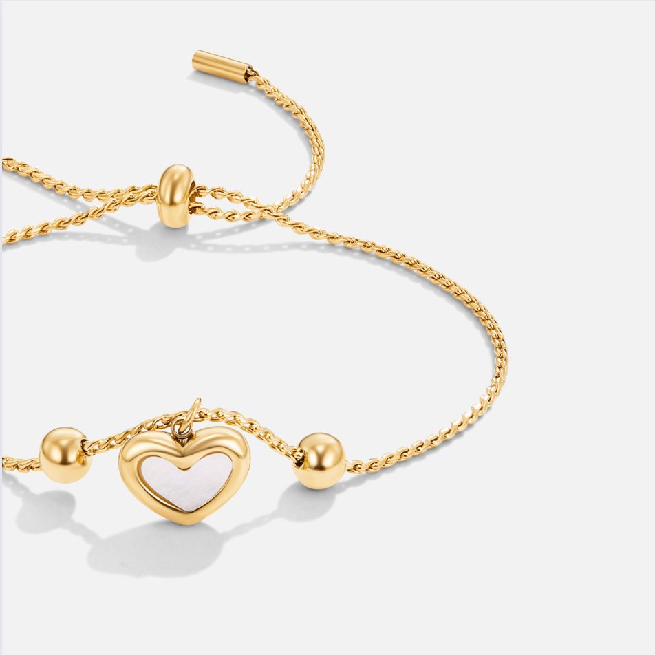 De SoulEmbrace armband, met een liefdevol ontwerp, beschikt over een delicate gouden ketting en een charmant hartvormig hangertje. Het tijdloze ontwerp, met de subtiele, elegante afwerking van de ballen aan de zijkanten, maakt het een perfect cadeau voor die speciale gelegenheid. Het verstelbare ontwerp zorgt voor optimaal draagcomfort, passend bij elke polsmaat.