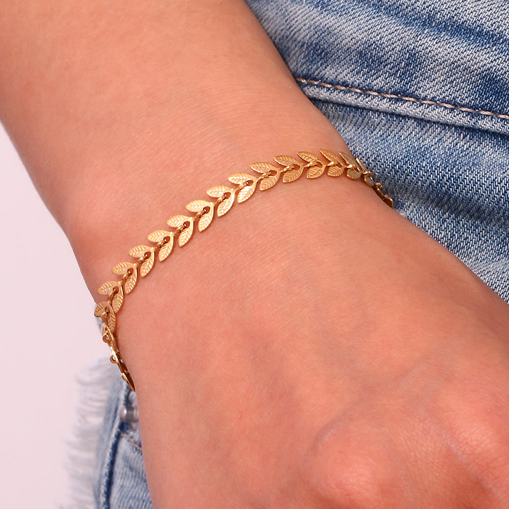 TwinkleCharms armband in goud met een verfijnd ontwerp van bladeren, perfect voor een elegante en tijdloze look. Het sieraad voegt een subtiele, luxueuze charme toe aan elke outfit.